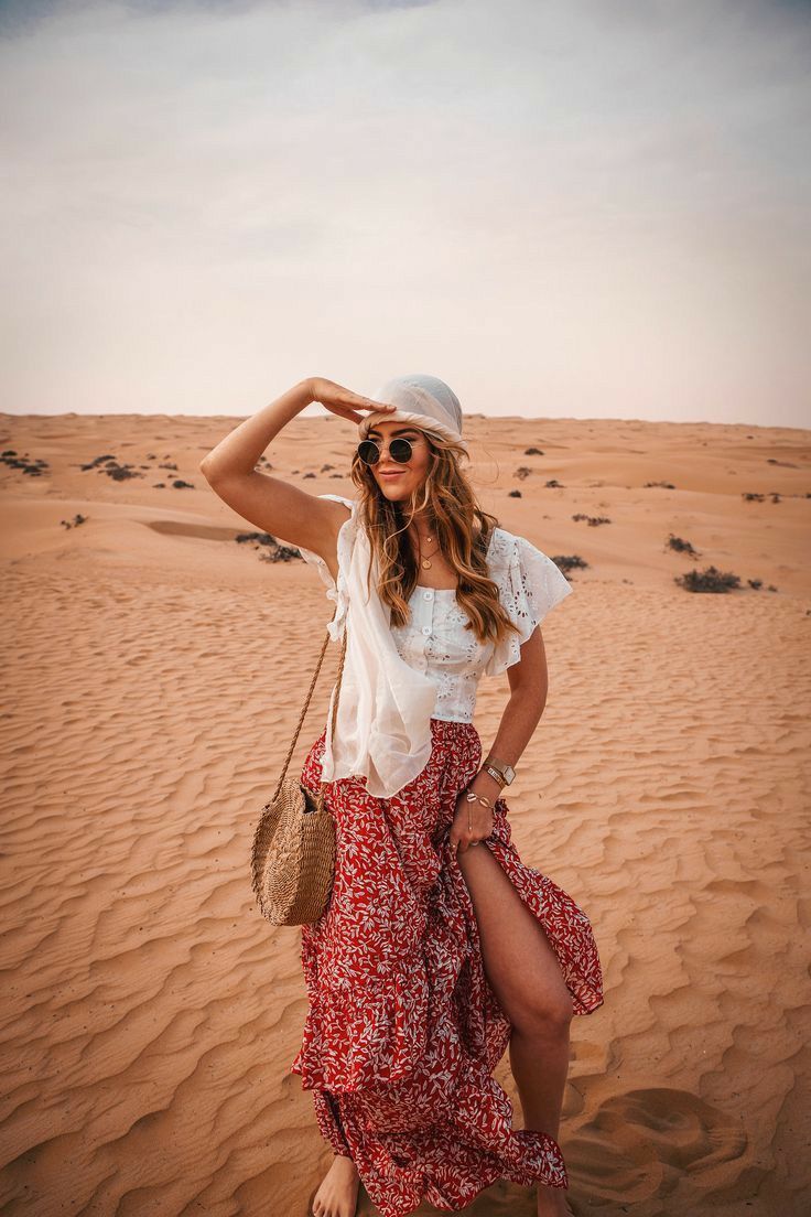 Lifestyle Dubai desert photoshoot with woman in flowing red skirt during warm golden hour