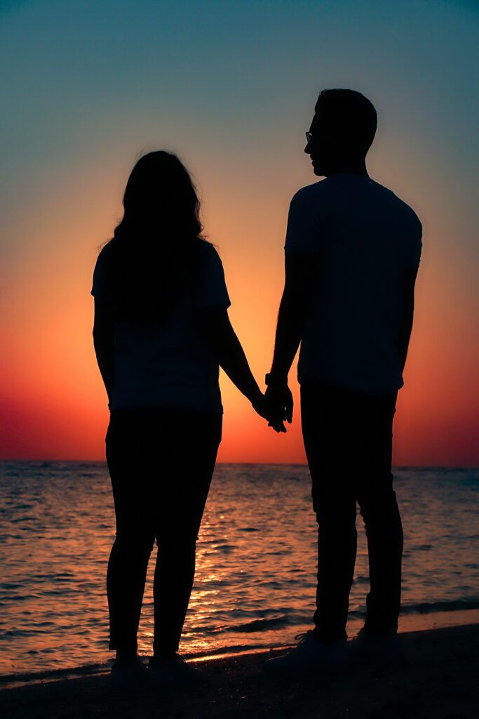 A couple in love, holding hands at sunset.







