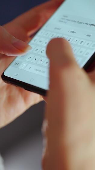 Close up of person typing message in dating app chat conversation on smartphone