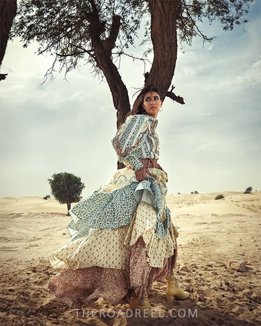 a girl during the day in Dubai Desert with desert trees in background