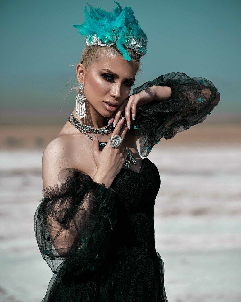 stylish girl posing in black dress and accesories in Dubai desert 