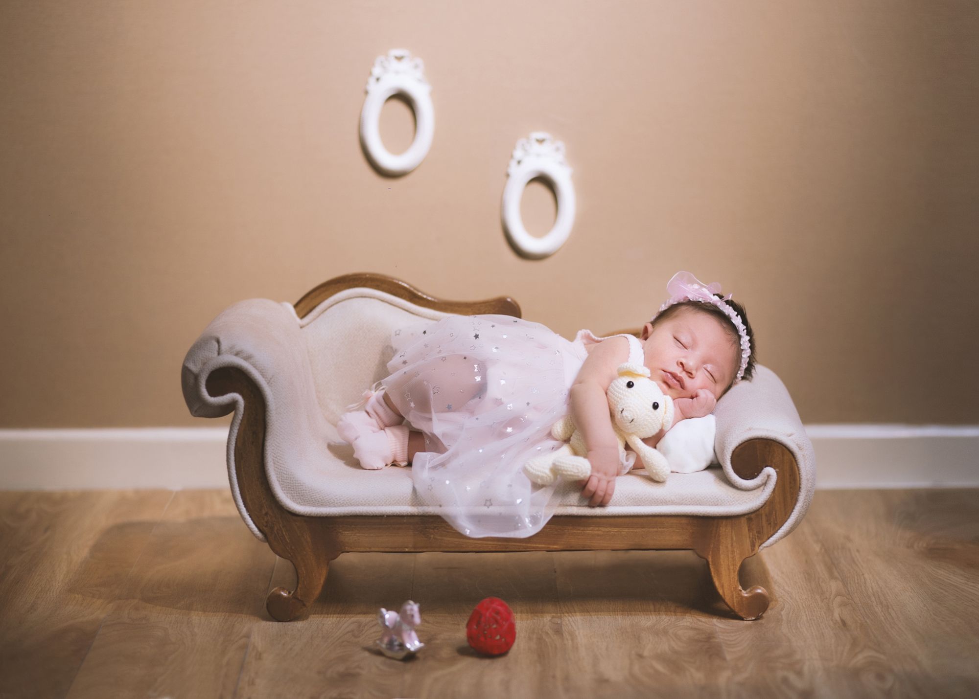 Newborn baby girl sleeping on a vintage sofa during a professional newborn photoshoot in Dubai