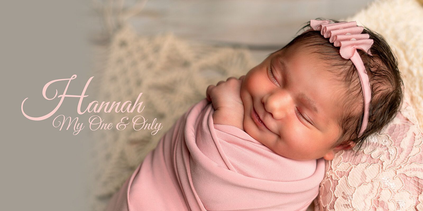 Newborn baby smiling in a pink-themed photography setup in Dubai and Abu Dhabi